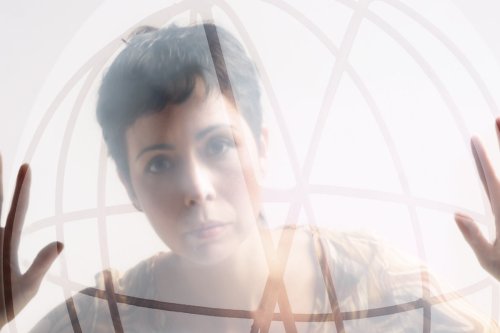 woman standing behind a transparent globe