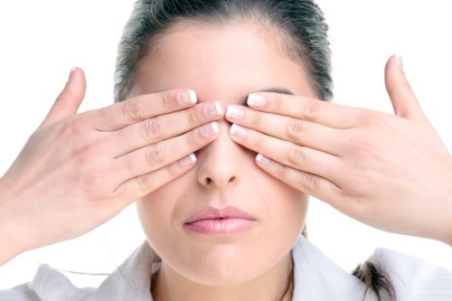 A woman covering her eyes with her hands