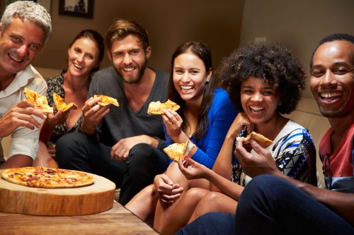 Group of young adults eating pizza