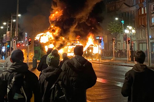 People watching a bus burning in Dublin, Ireland during the 2023 riots.