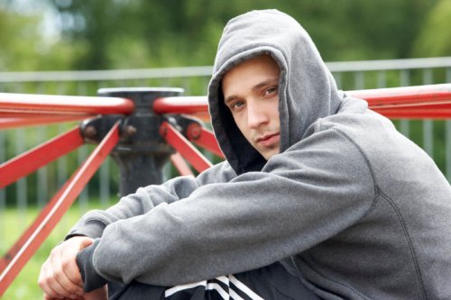 Young Man Sitting In Playground