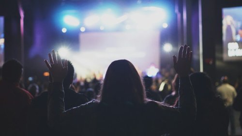 Woman with hands raised worshiping at church