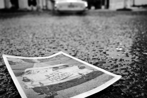 Photo lying on pavement of a car with a just married sign on trunk
