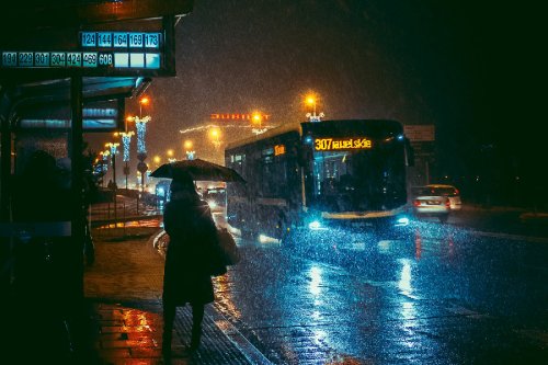 Woman holding an umbrella on a rainy night