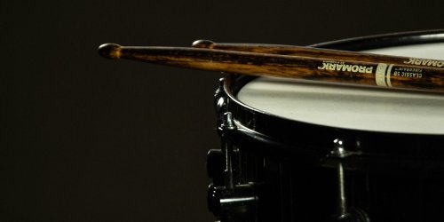 A drum and sticks on a black background
